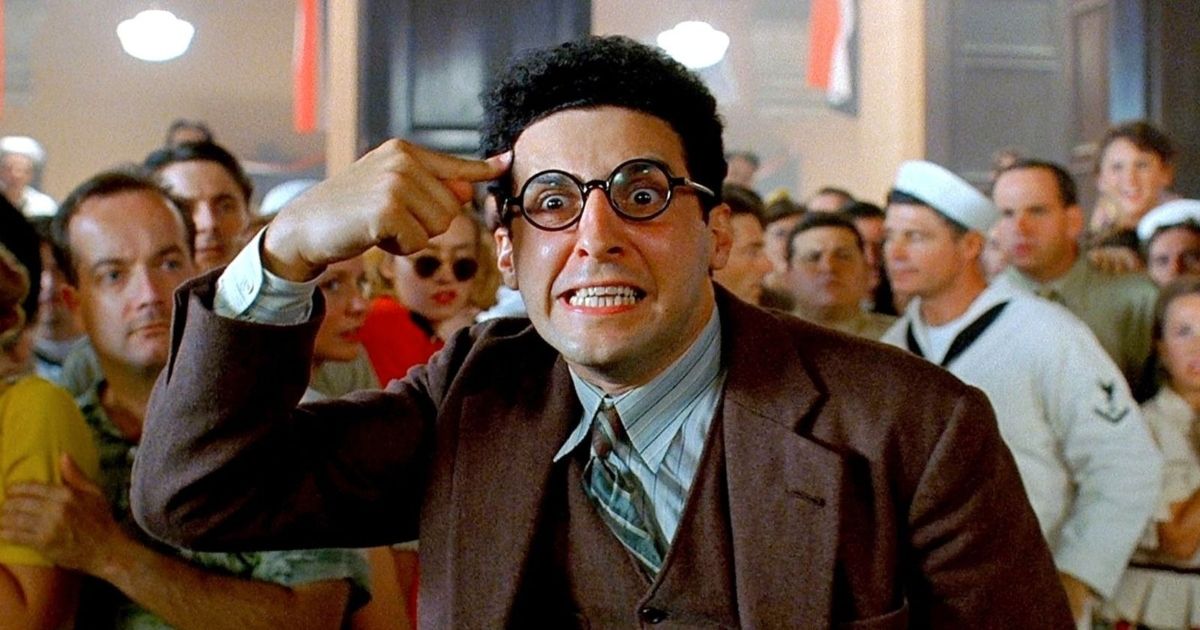 John Turturro fazendo uma expressão facial humorística como Barton Fink no filme de 1991. 