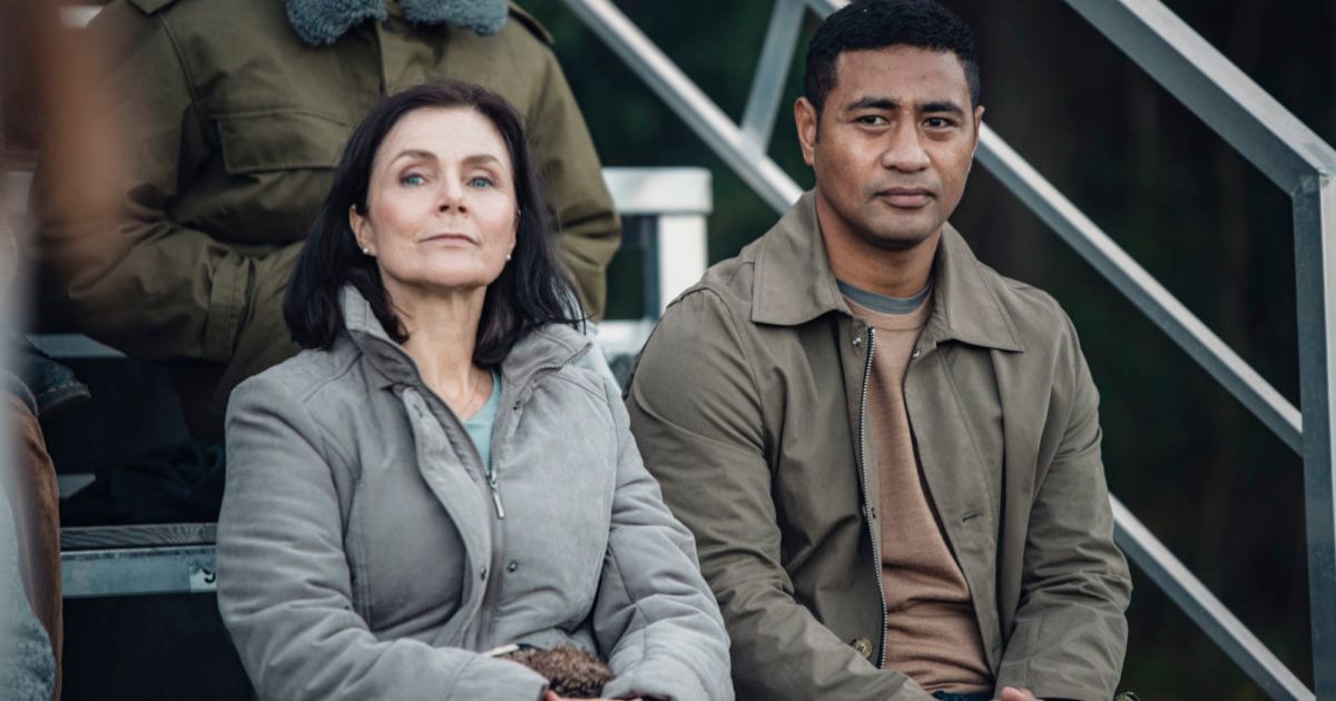 Beulah Koale sits with the mother character on bleachers in Dual