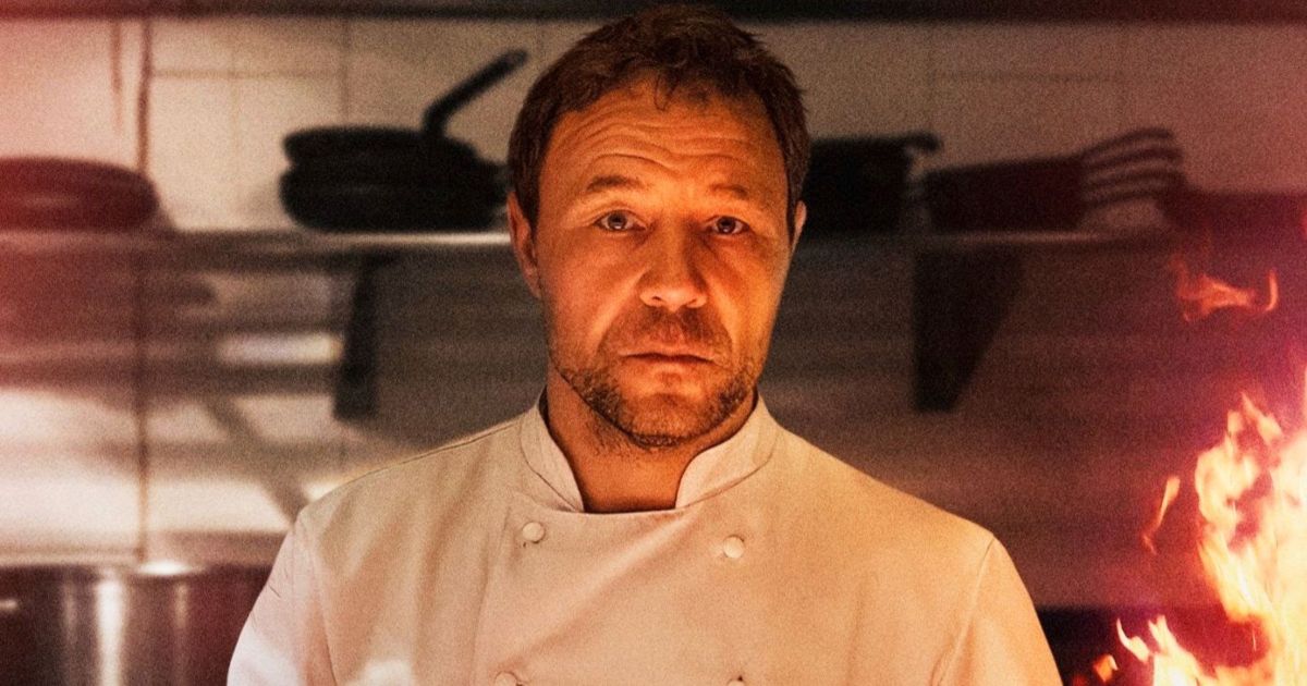 Stephen Graham in a chefs coat by an open flame in Boiling Point 