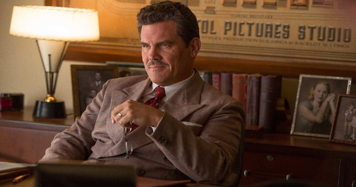 Josh Brolin in a suit and mustache sits in Hail Caesar