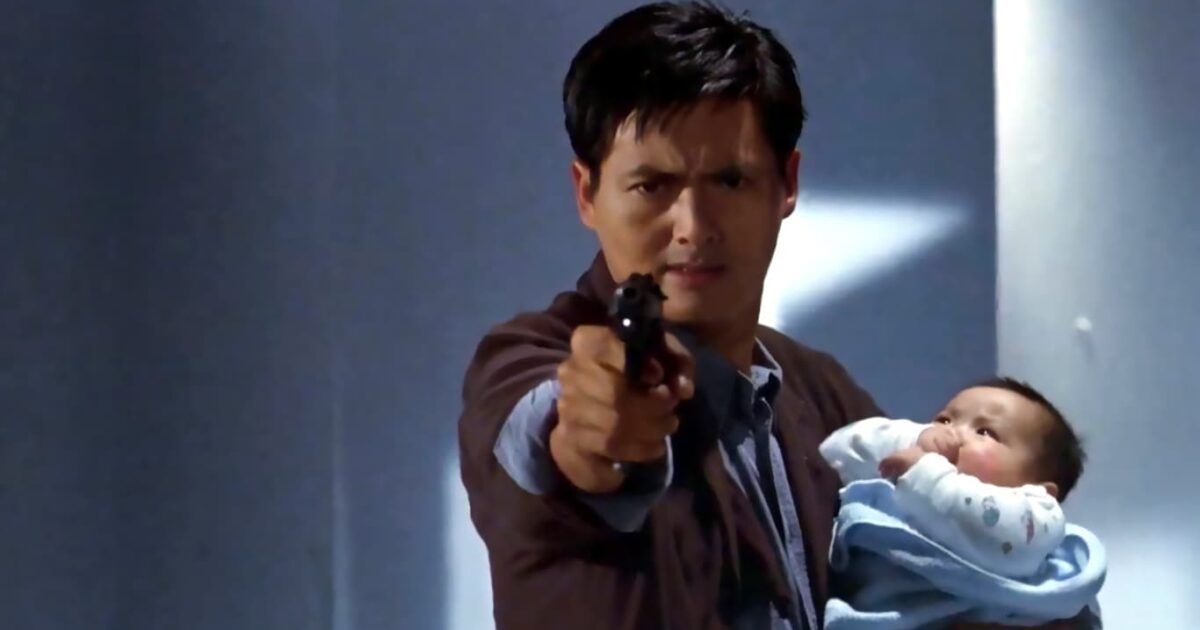 Chow Yun-Fat holds a baby and a gun in Hard Boiled