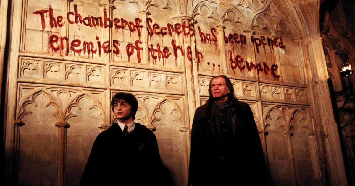 Harry Potter stands in front of the blood-red writing on the wall in Harry Potter and the Chamber of Secrets