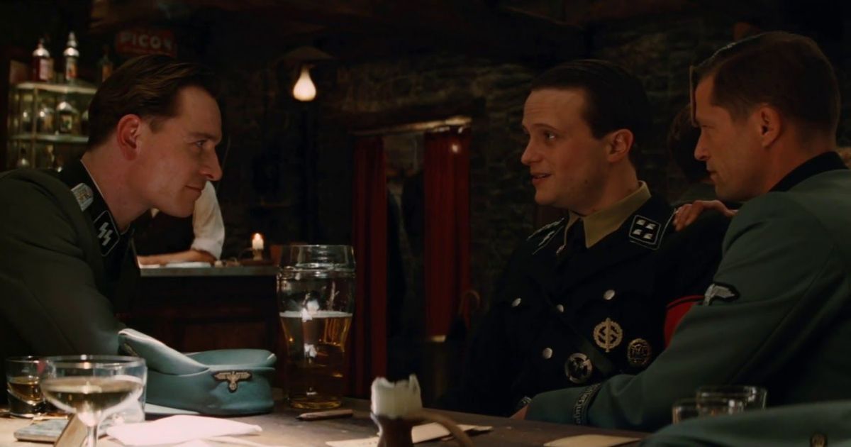 Fassbender como un soldado hablando con otros en un bar en Inglourious Basterds