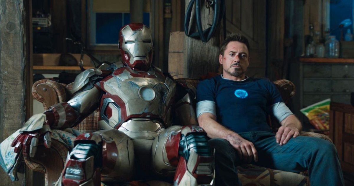 Iron Man sits next to a cyborg on a couch