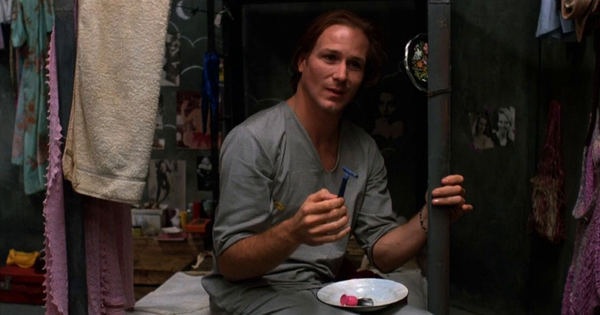 William Hurt with long hair meditating in prison in Kiss of the Spider Woman