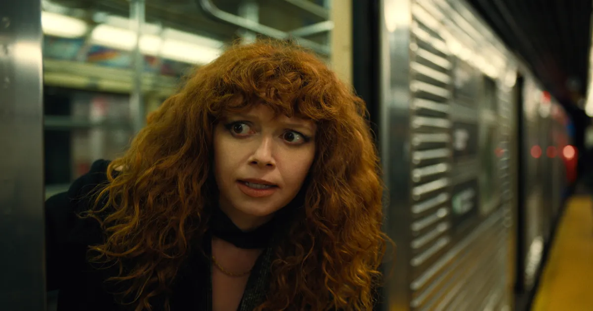 Nadia sticks her head out of a subway train door in Russian Doll