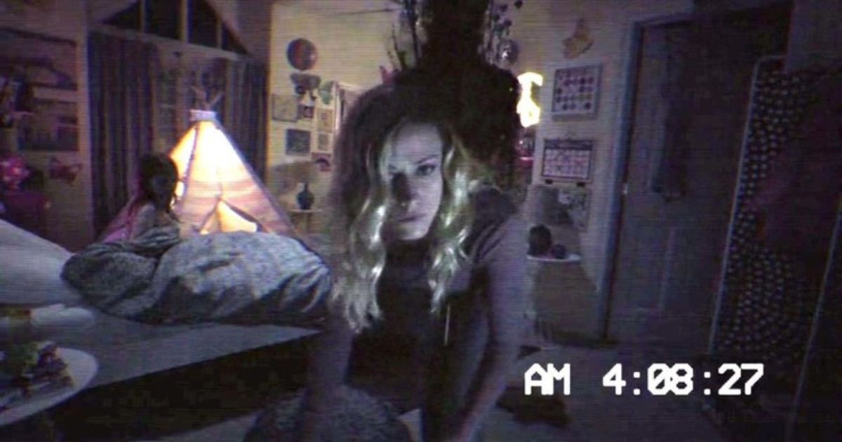 Tobi appears behind the main woman in a bedroom in Paranormal Activity The Ghost Dimension