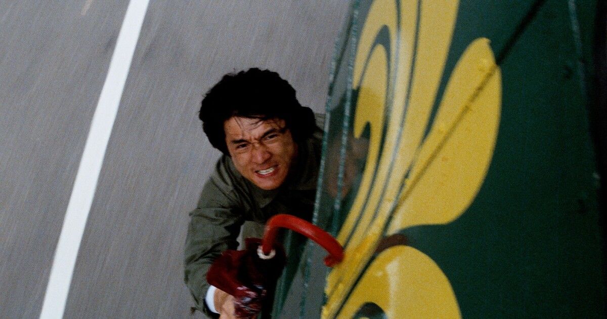 Jackie Chan hangs from a bus in Police Story