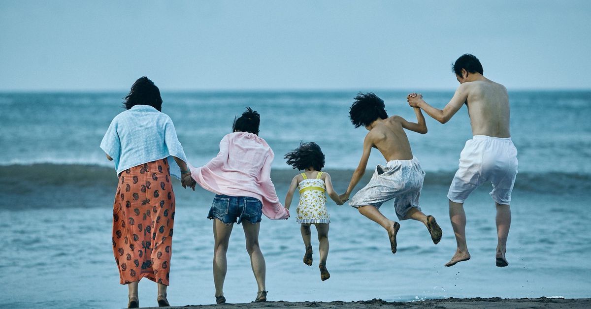 The family of Shoplifters jump by the ocean