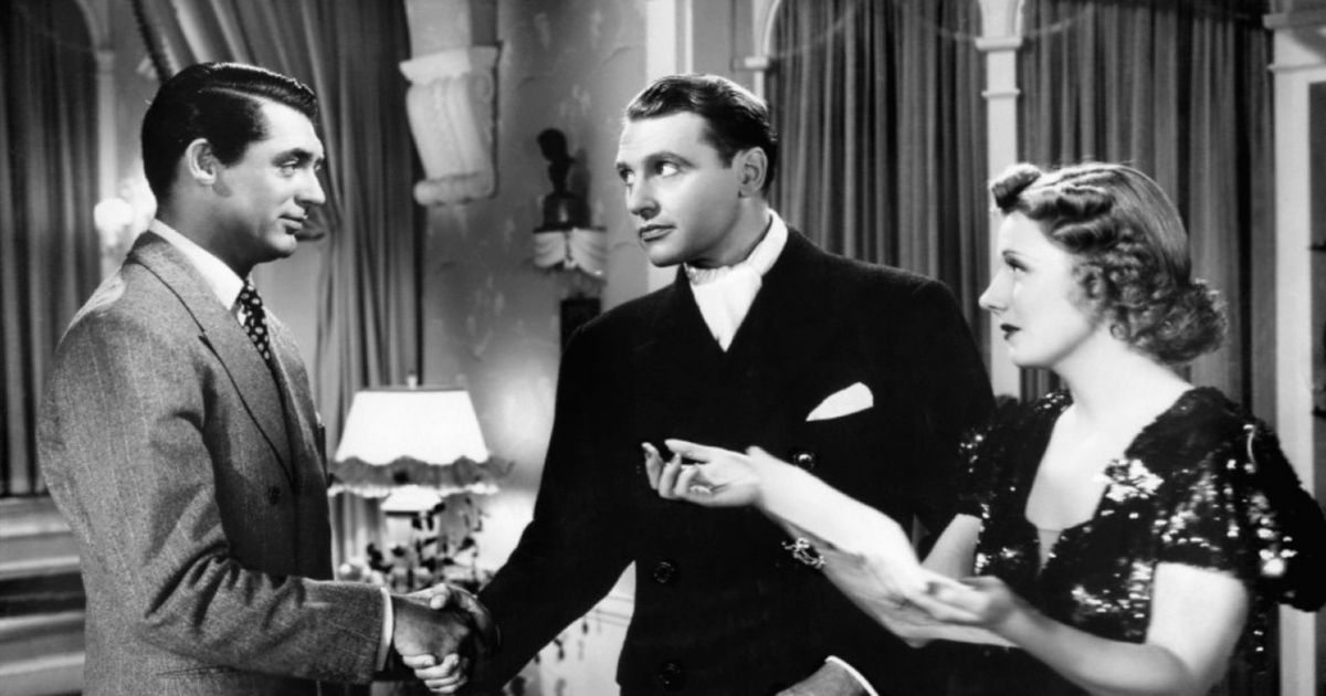 Cary Grant on the left shaking a man's hand in The Awful Truth
