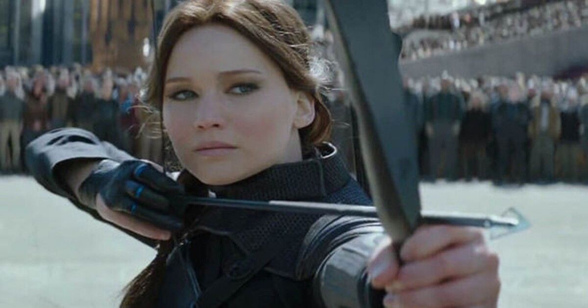 Jennifer Lawrence pulling a bow and arrow as Katniss in The Hunger Games