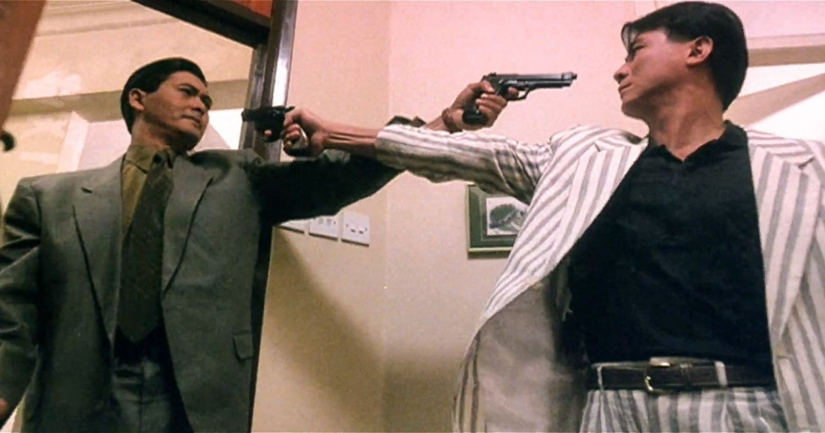 Two characters in The Killer pointing guns at each other's heads.