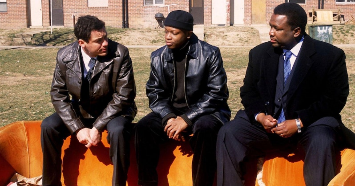 Two cops sit on either side of a young drug dealer in The Wire