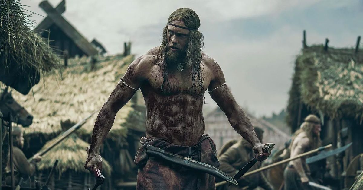 A blood-soaked shirtless Viking flexes in a village in The Northman