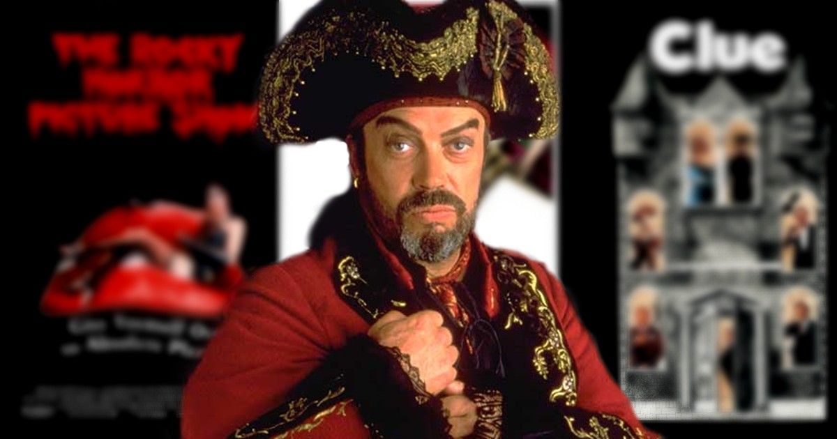 Tim Curry in a pirate outfit standing in front of Clue and Rocky Horror Show posters
