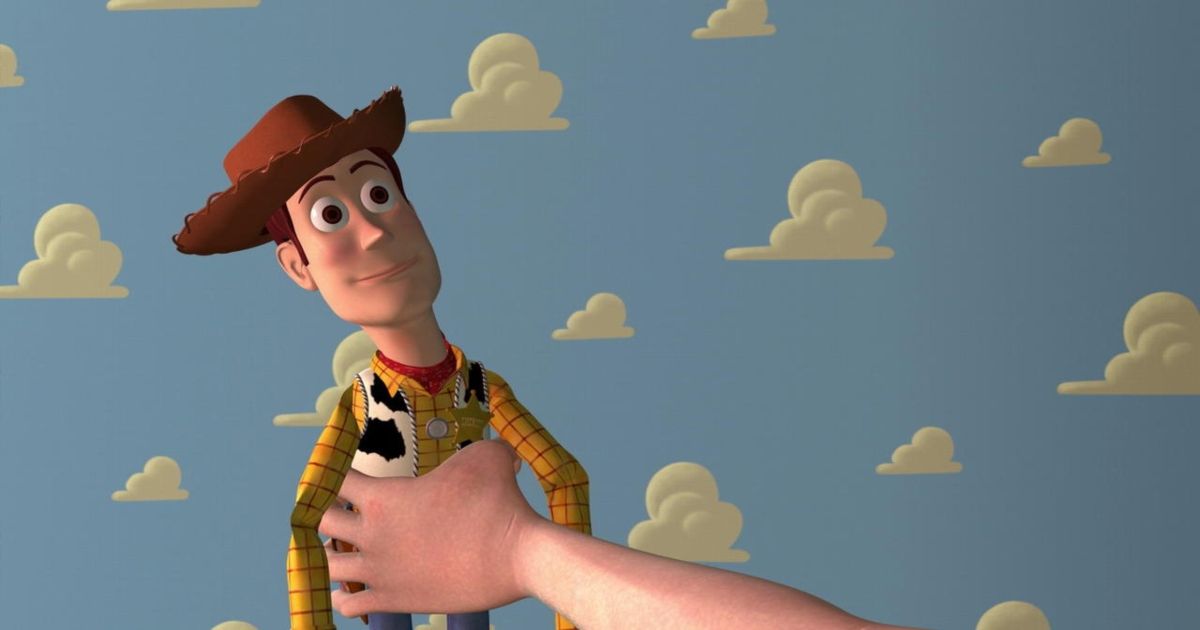 Woody is held by a hand in Toy Story