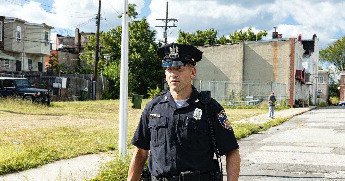 Police officer walks on sidewalk in Baltimore
