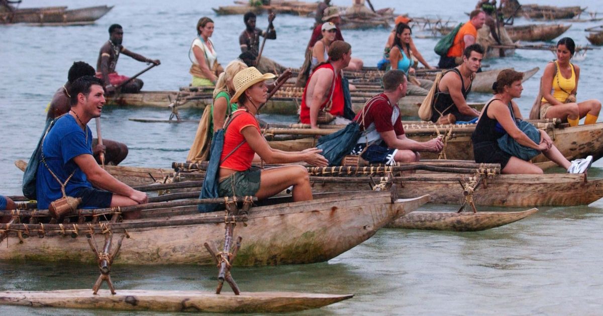 The cast of Survivor Borneo traveling together in several boats.