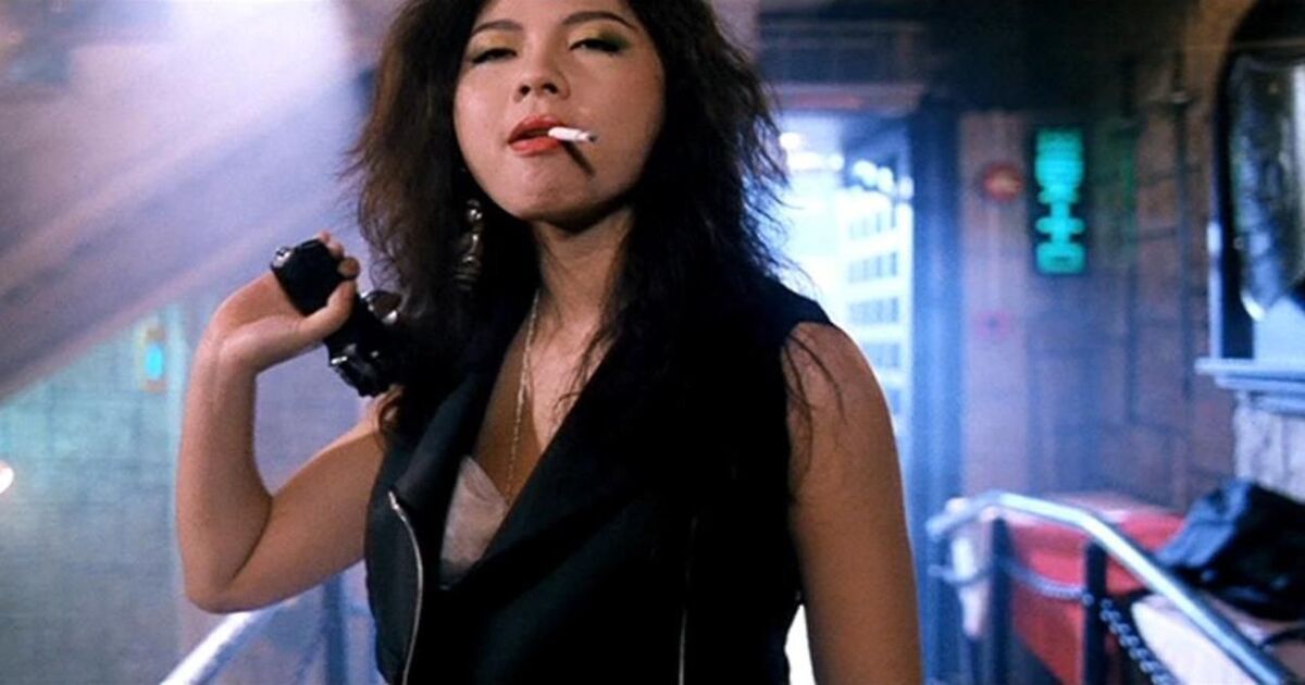 A woman smokes with a cigarette and a gun in Full Contact