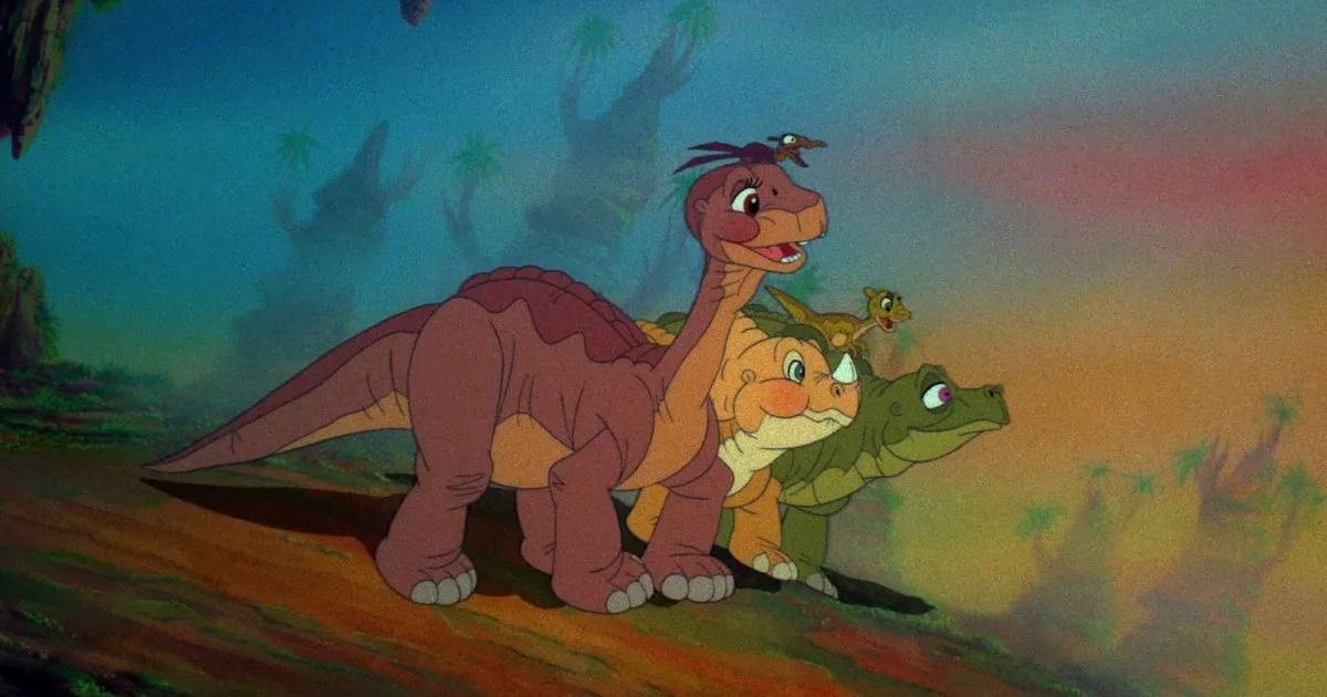 Animated dinosaurs in The Land Before Time look out over a valley. 