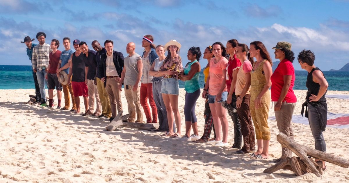 The cast of Survivor's Winners at War season lined up on a beach.