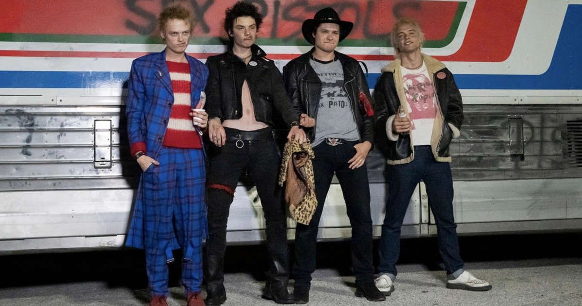 Punk band stands in front of wall that says Sex Pistols