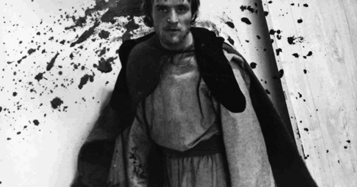 Man stands in front of paint splatters in Andrei Rublev