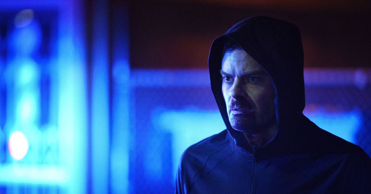 Barry in a hoodie at night with blue lights