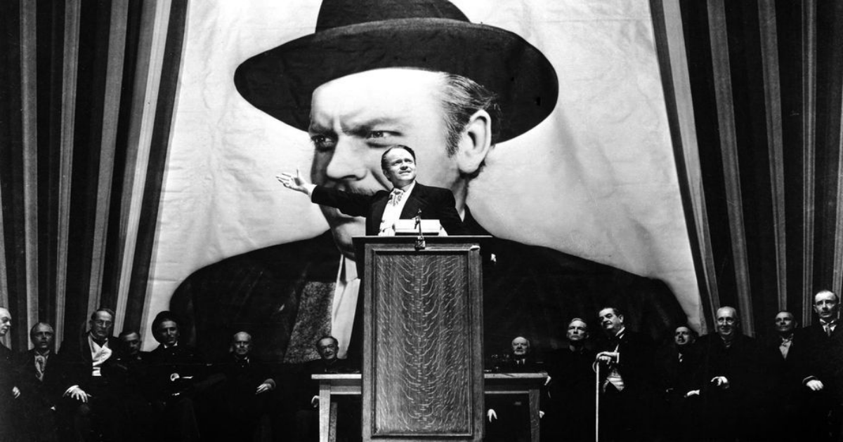Orson Welles gives a campaign speech in front of a big image of himself in Citizen Kane 