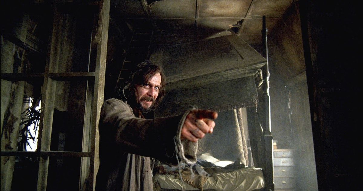 Man points wand at someone off-screen while standing in abandoned house.