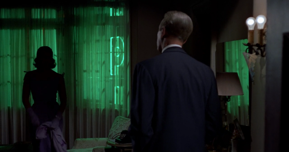 Jimmy Stewart looks at Kim Novak in the green-lit room of Vertigo