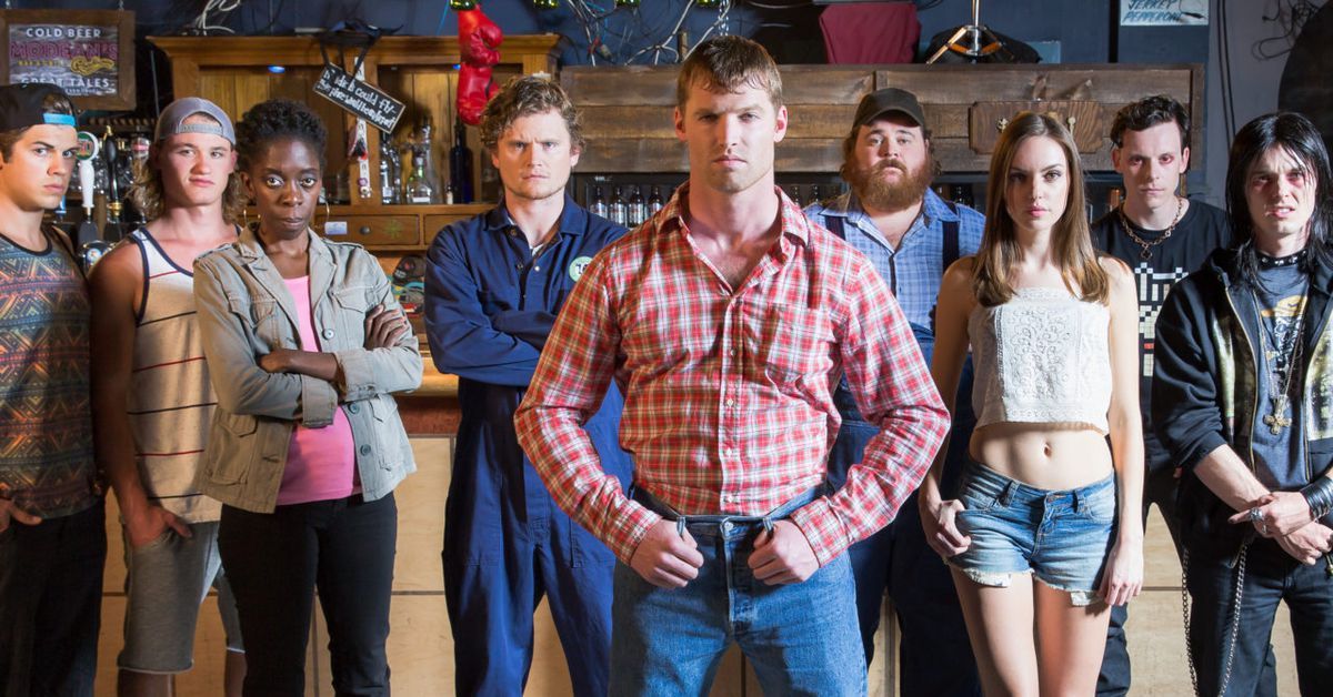 Letterkenny Cast standing at the bar with Jared Keeso in the center front