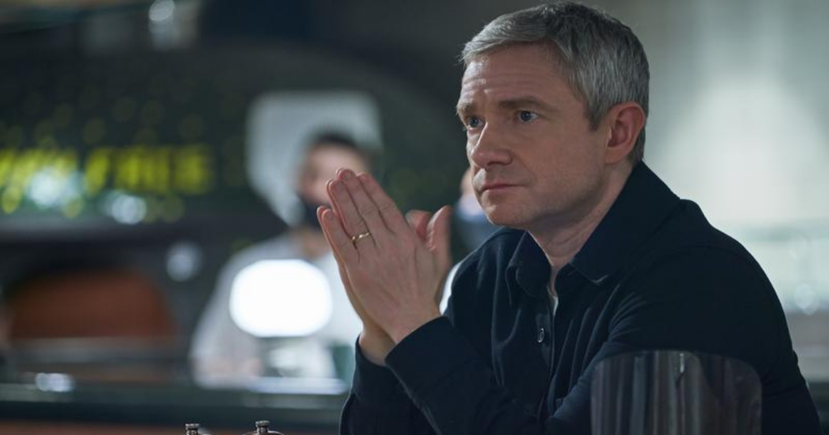 Martin Freeman holding his hands up like a prayer in a suit in Breeders