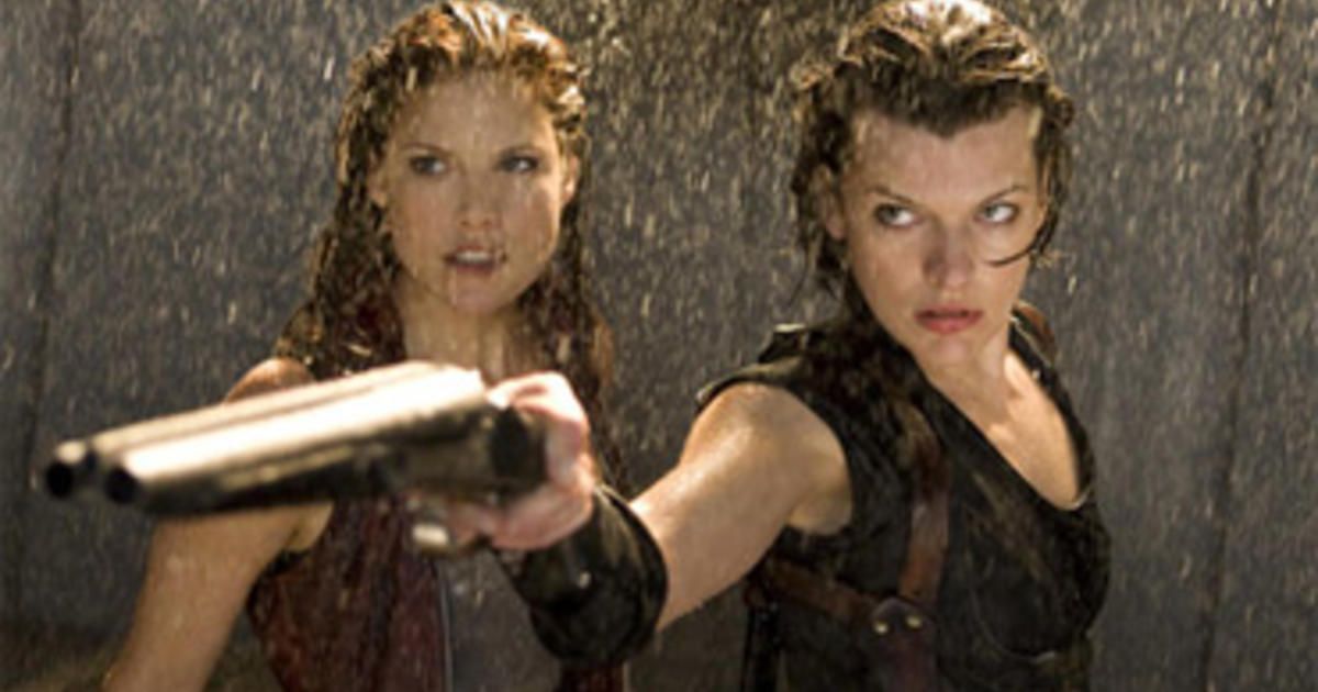 Resident Evil Milla Jovovich holds a shotgun in the rain