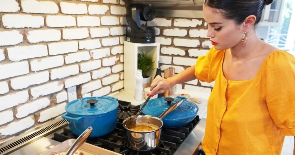 Selena Gomez stirring something in a pot in her kitchen for Selena + Chef.