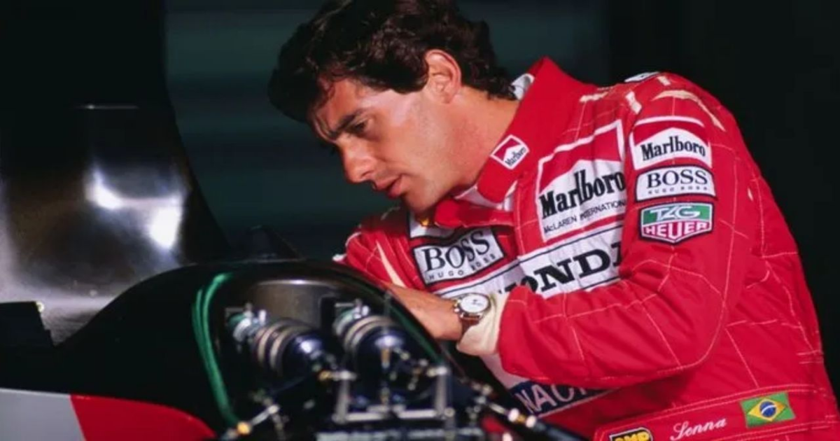 Senna in his red Formula 1 outfit working on a car