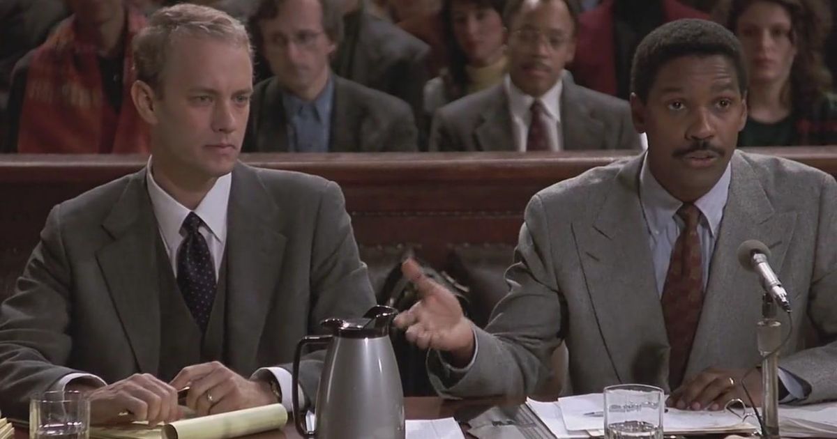 Tom Hanks e Denzel Washington sentados em um tribunal no filme Filadélfia