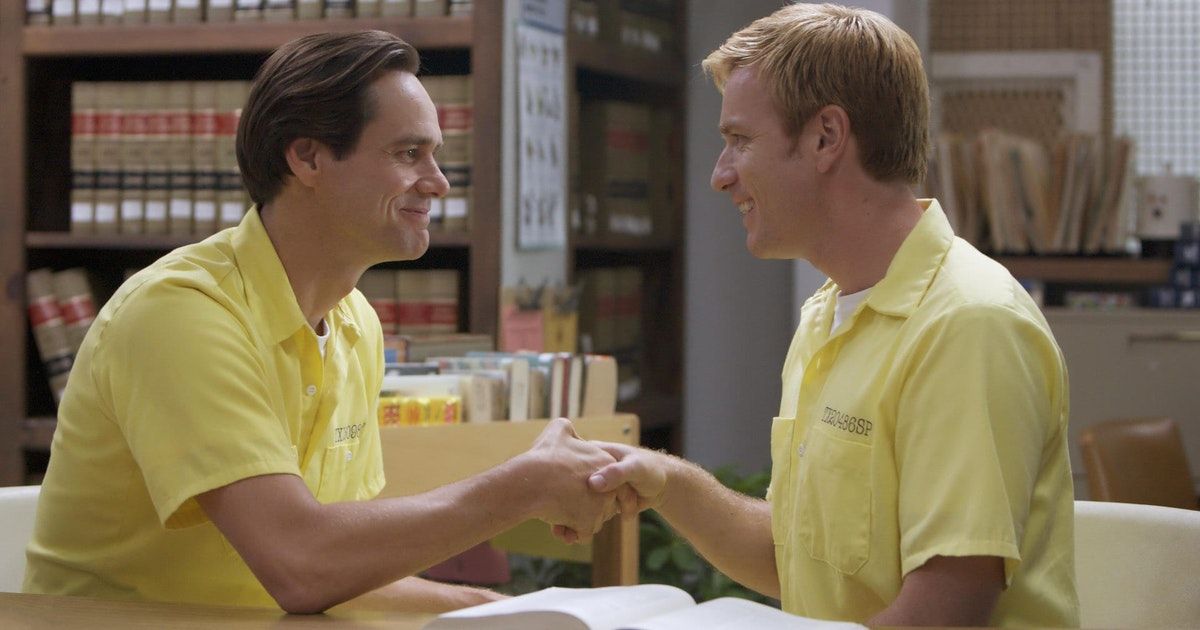 Two men in yellow shirts shake hands.