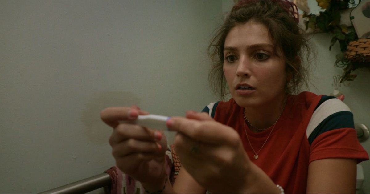 Alex Trewhitt as Cherry checks her pregnancy test in the bathroom in Cherry
