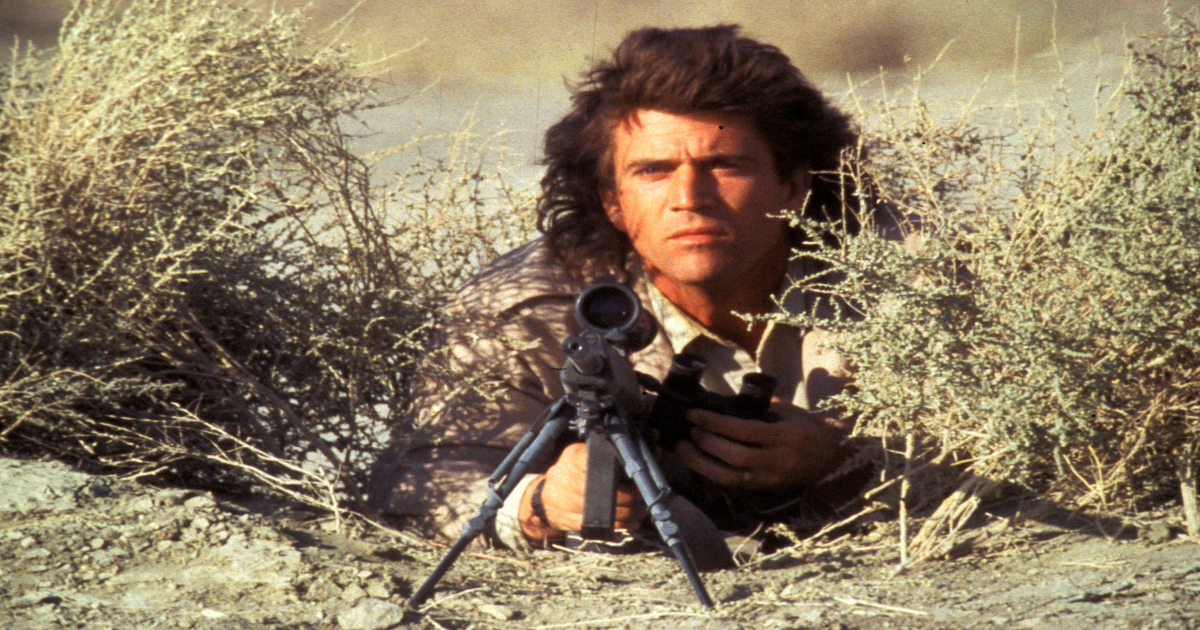 Mel Gibson with a gun aiming to shoot