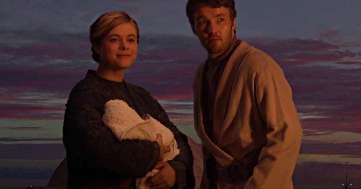 Man and woman hold baby in sunset.