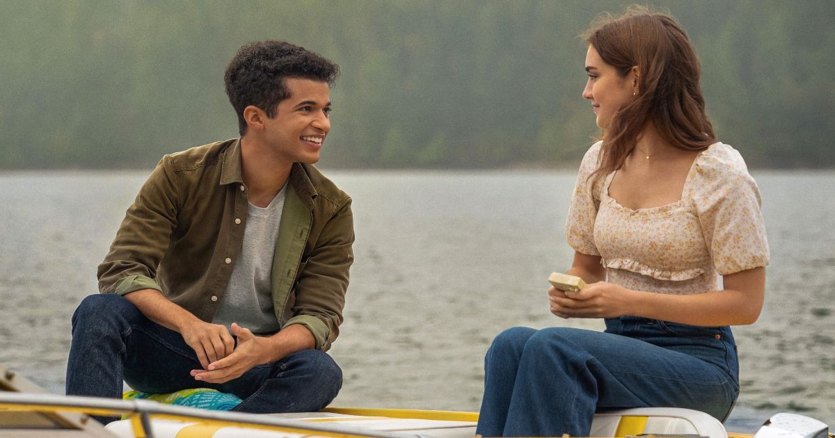 Boy and girl sit on boat together.