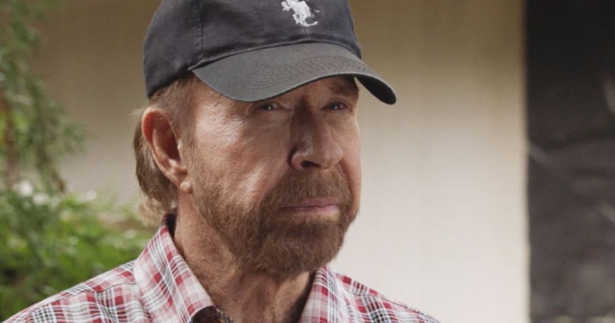 Chuck Norris wearing a red and white flannel and a black hat in Hawaii Five-0 