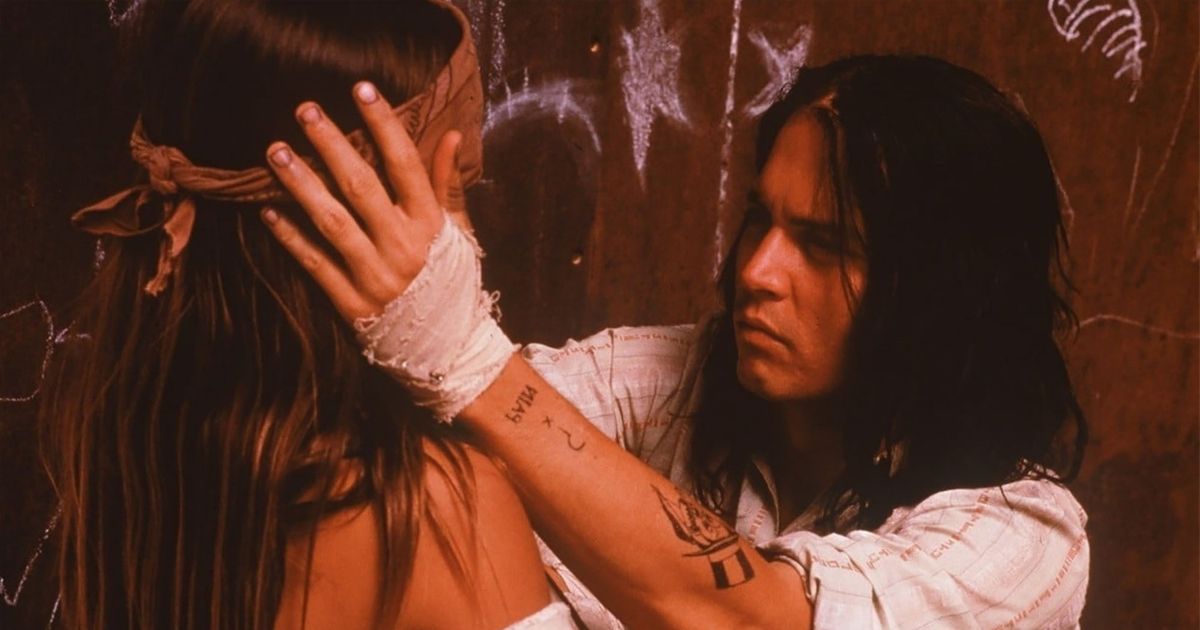 Johnny Depp as the Indigenous Raphael holding his wife in his movie The Brave