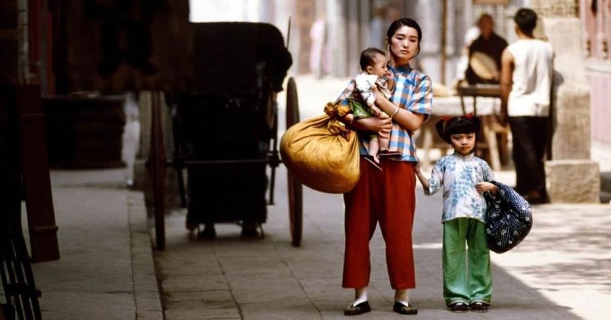 A woman walks with two children.