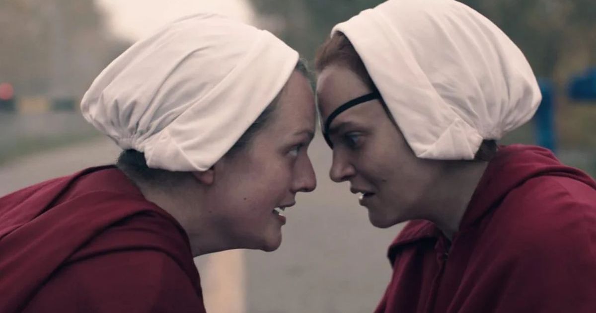 The Handmaid's Tale stars June (Elizabeth Moss) and Janine (Madeline Brewer) leaning in toward each other's faces.