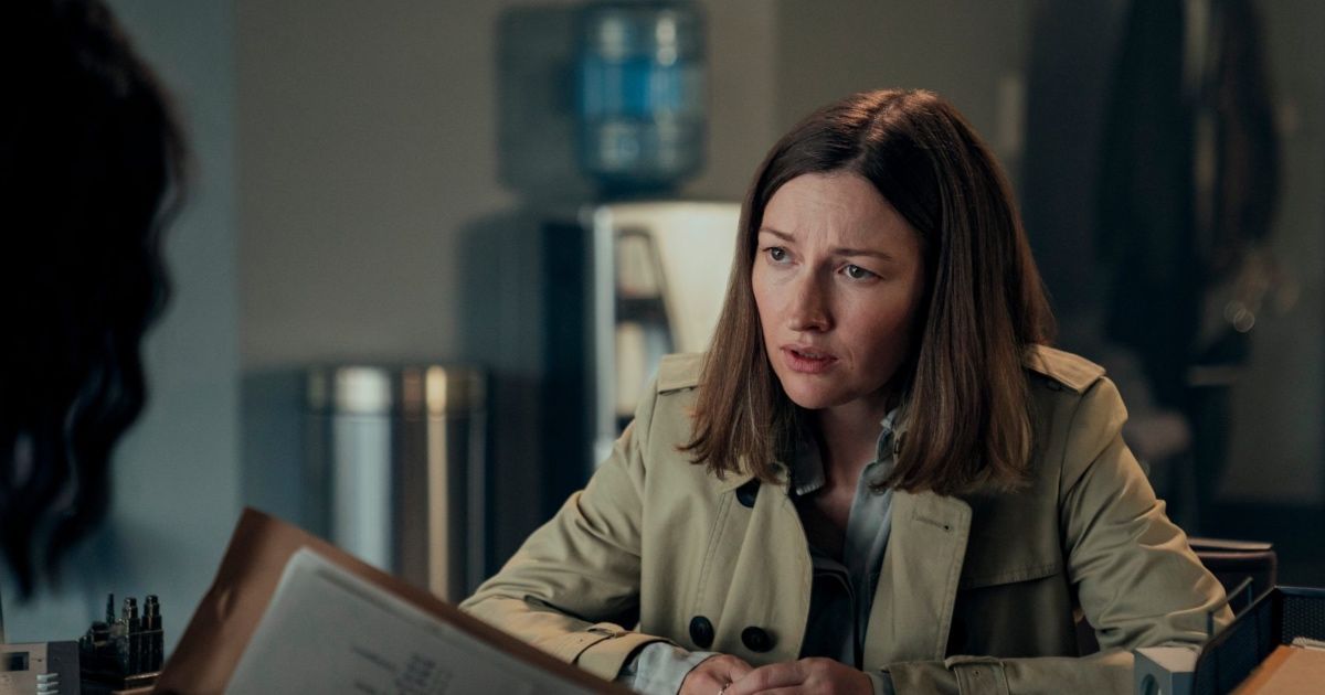 Woman sits at desk looking concerned.