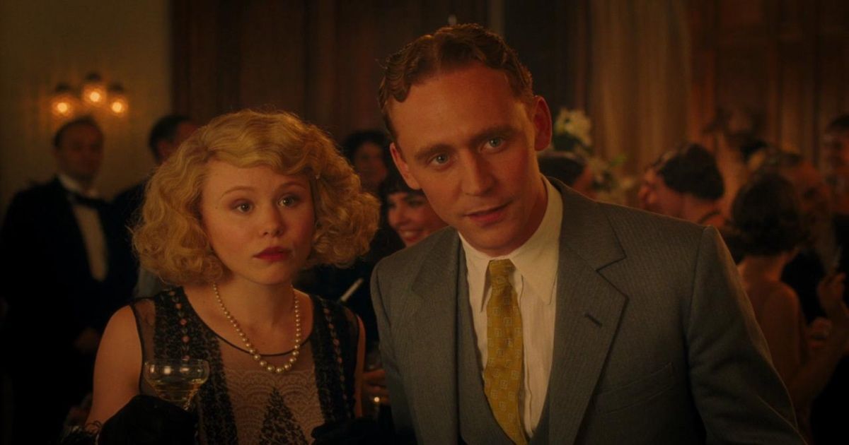 Man and woman stand dressed in 1920s styles at party