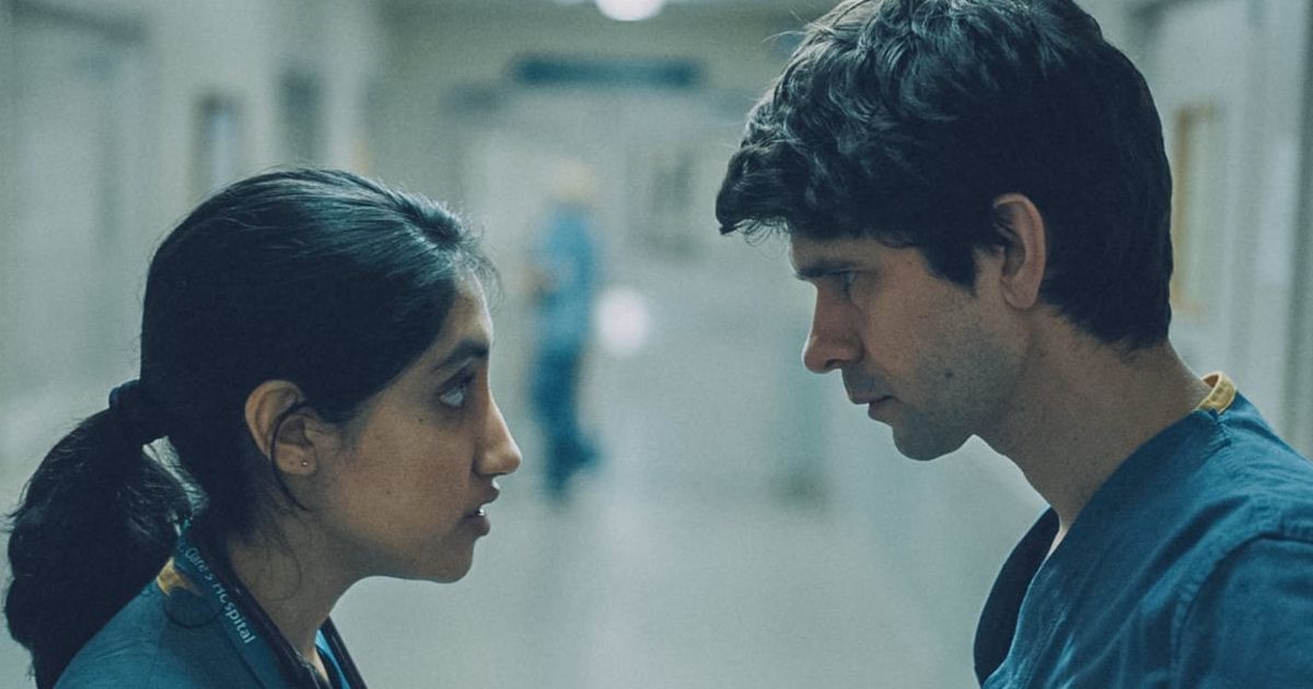 Man and woman doctors talk seriously in hallway.