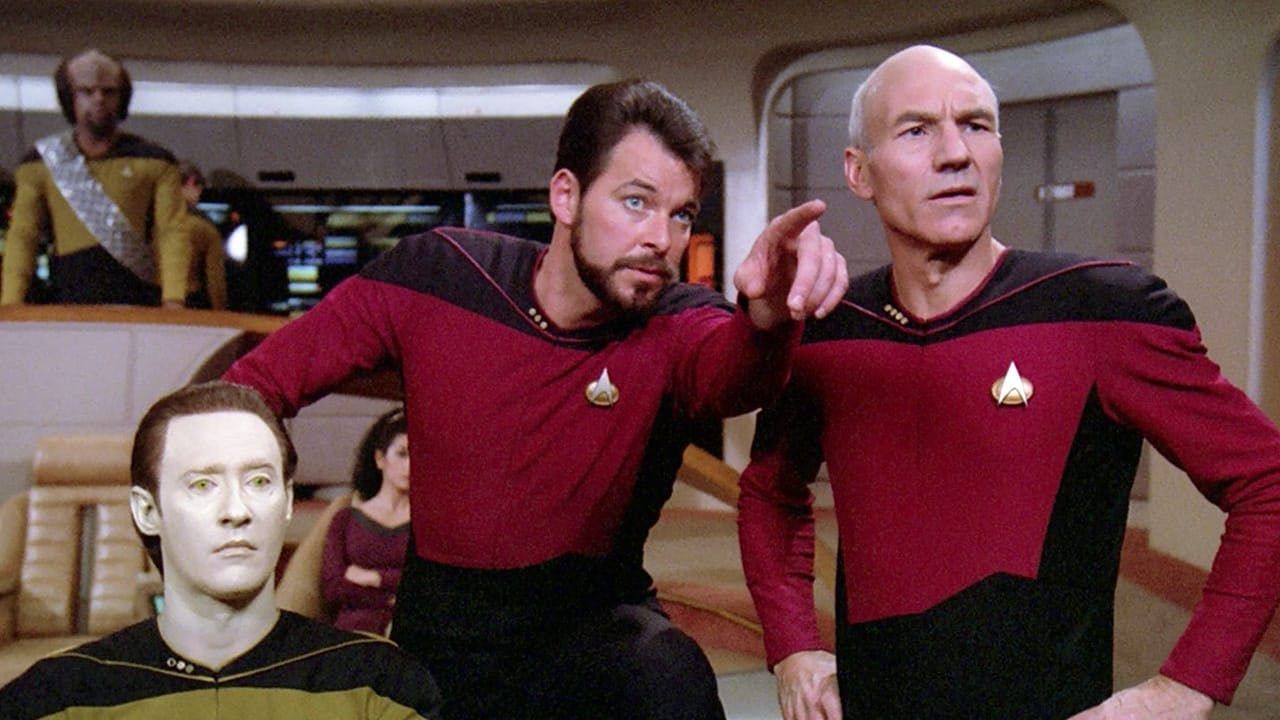 Riker points out something to Picard